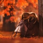Сумна жінка задумливо дивиться у вікно, замислена про стосунки