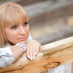 Дівчина замислено посміхається, думаючи про хлопця