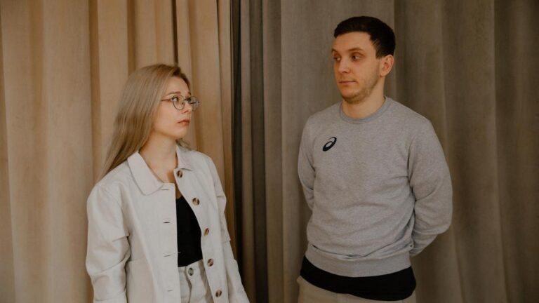 Сумна жінка сидить поруч із байдужим чоловіком у кімнаті